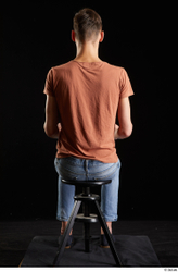 Alessandro Katz  black shoes blue jeans brown t shirt casual dressed sitting whole body  jpg